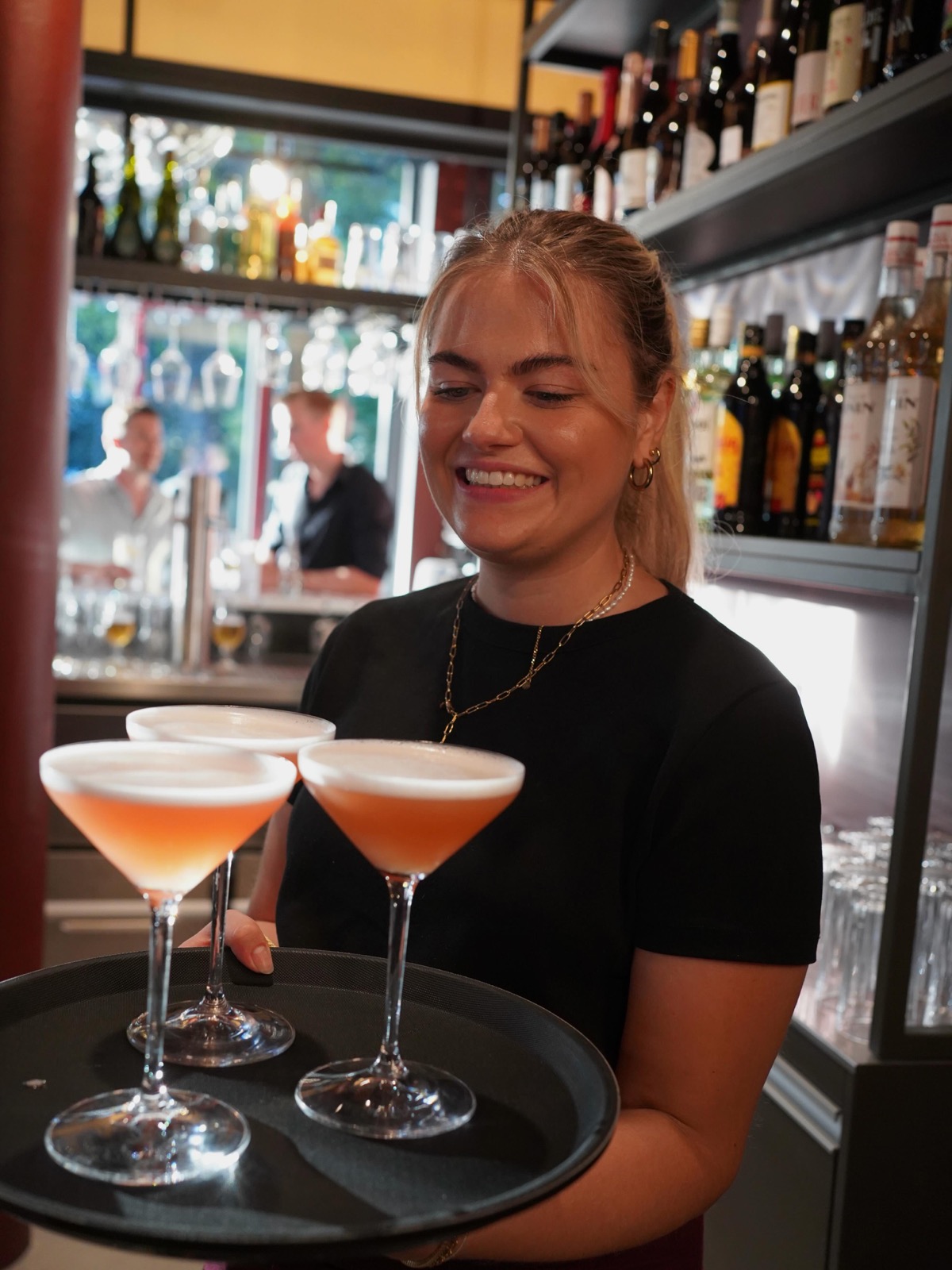 Kellnerin serviert Cocktails an der Bar